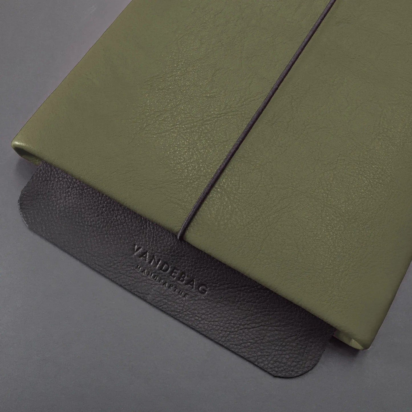 grüne Macbookhülle mit schwarzer Verschlussklappe mit Vandebag Prägung