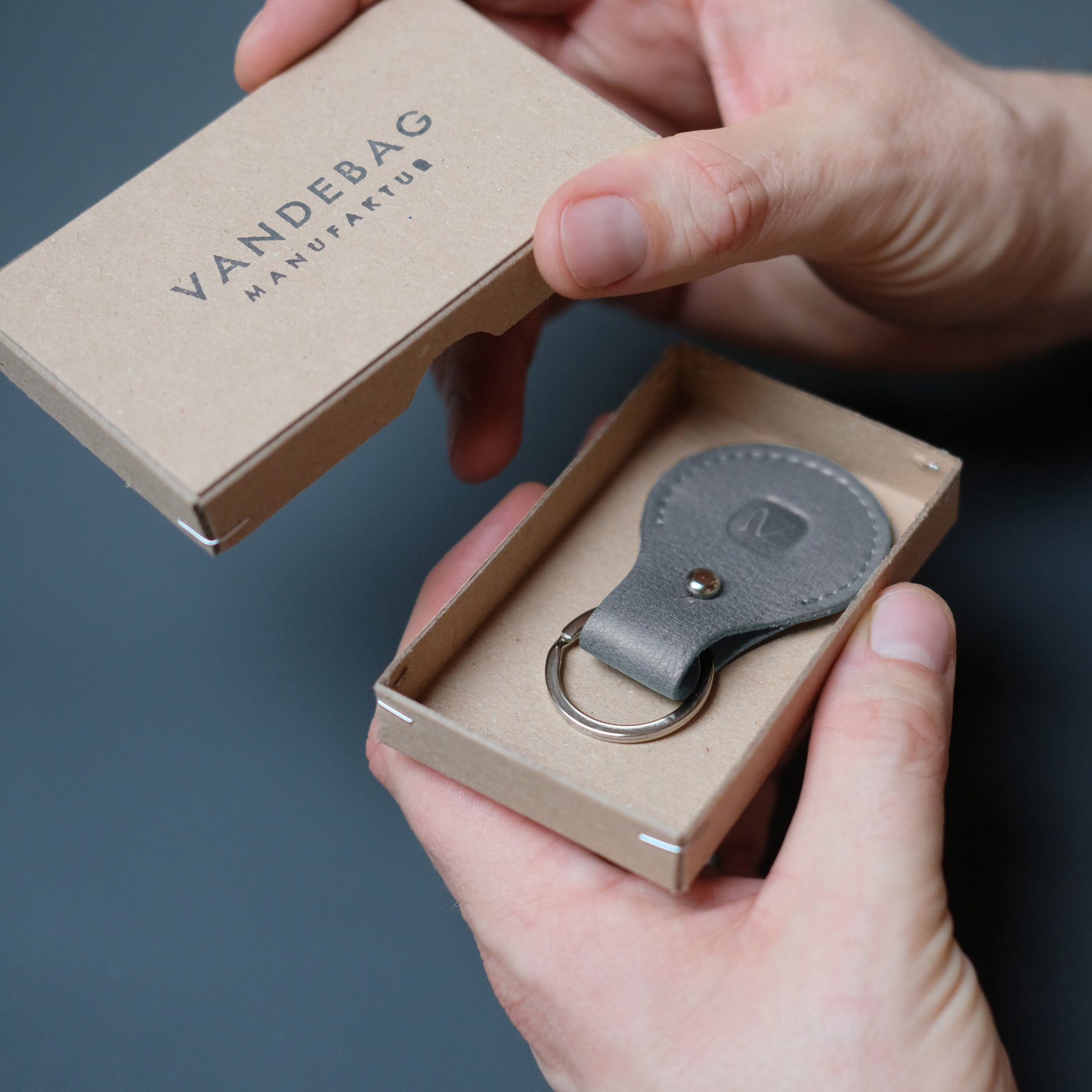 grauer Airtag Schlüsselanhänger aus Leder in Geschenk Karton