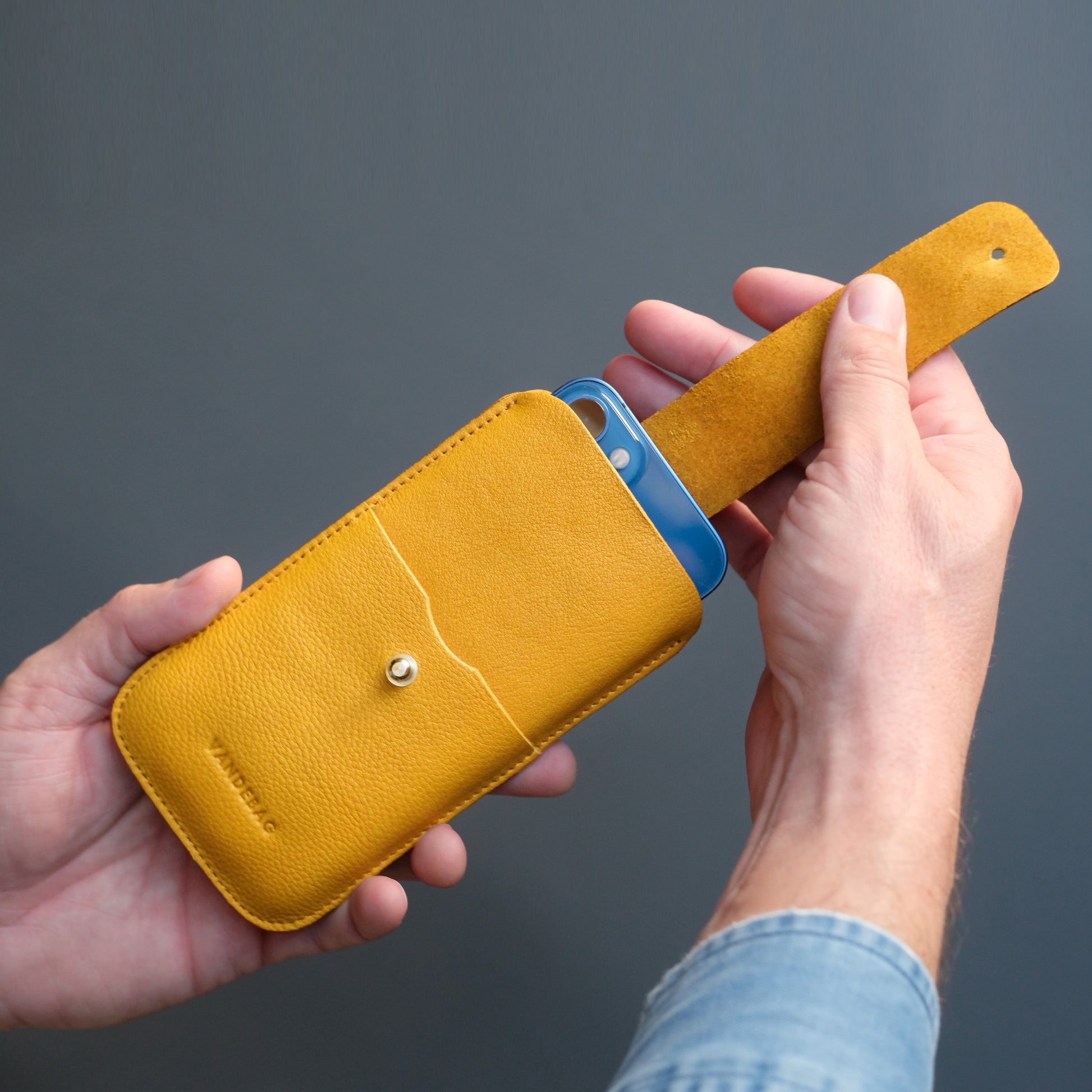 Handy wird an verschlusslasche aus dem gelben Case gezogen