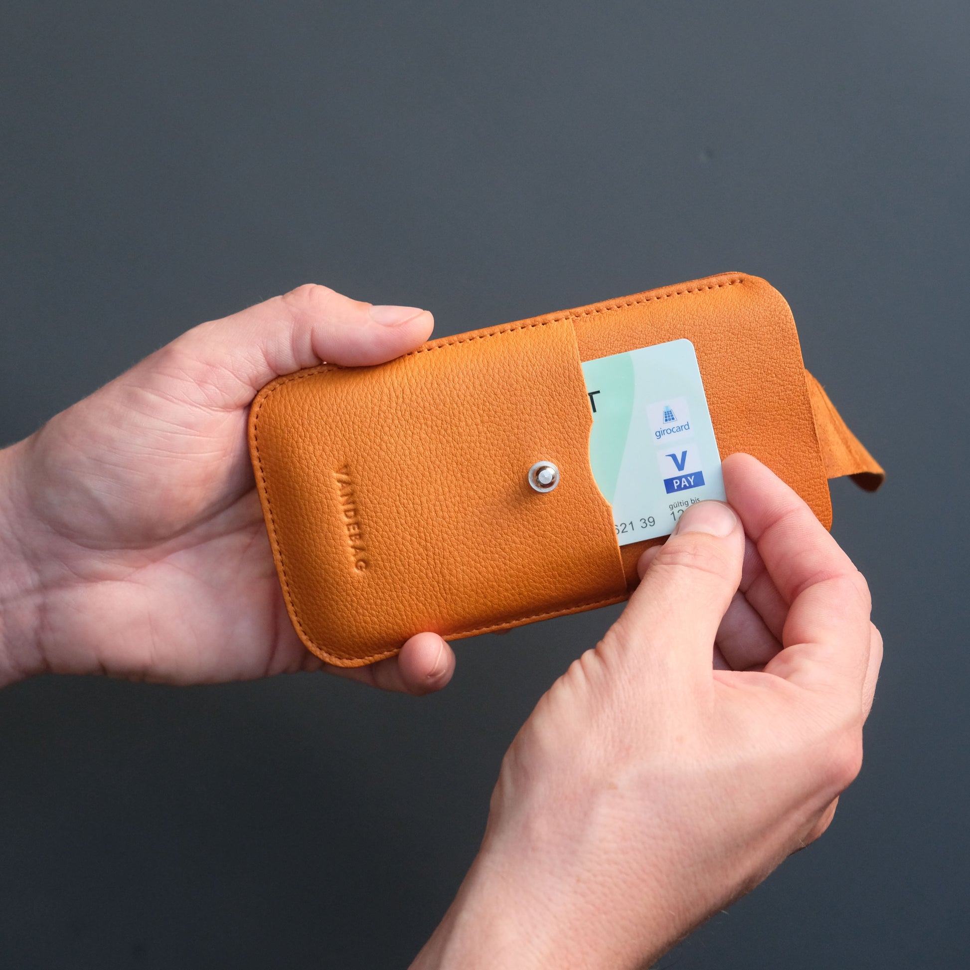 Handyhülle aus orangefarbenem Leder mit integriertem Kartenfach
