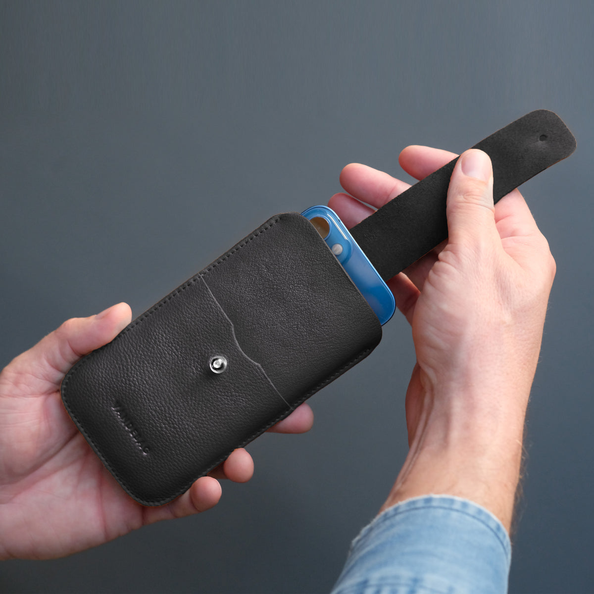 iPhone wird mit Zuglasche aus Handy Sleeve gehoben