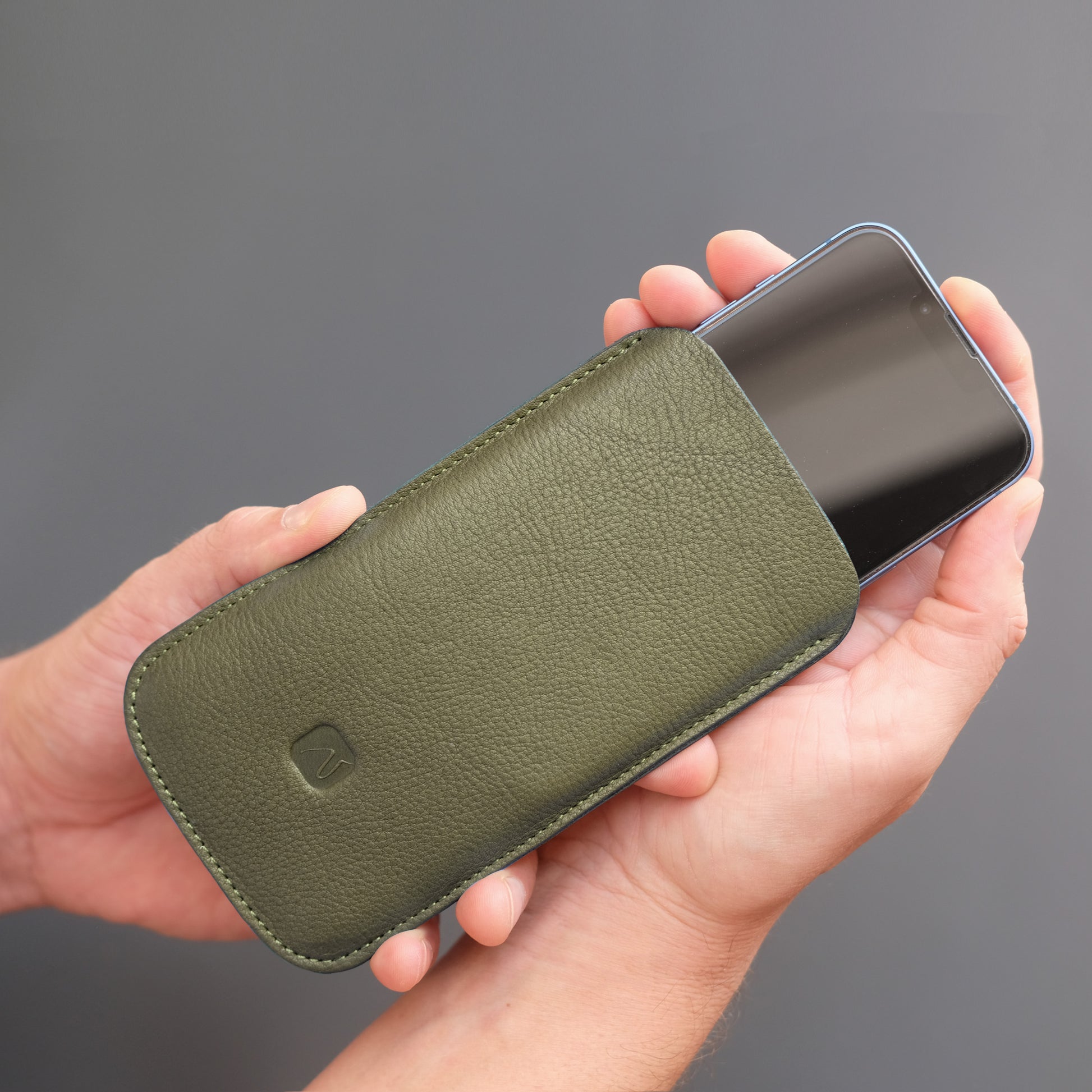 iPhone wird in olivgrünes Handy Sleeve gesteckt