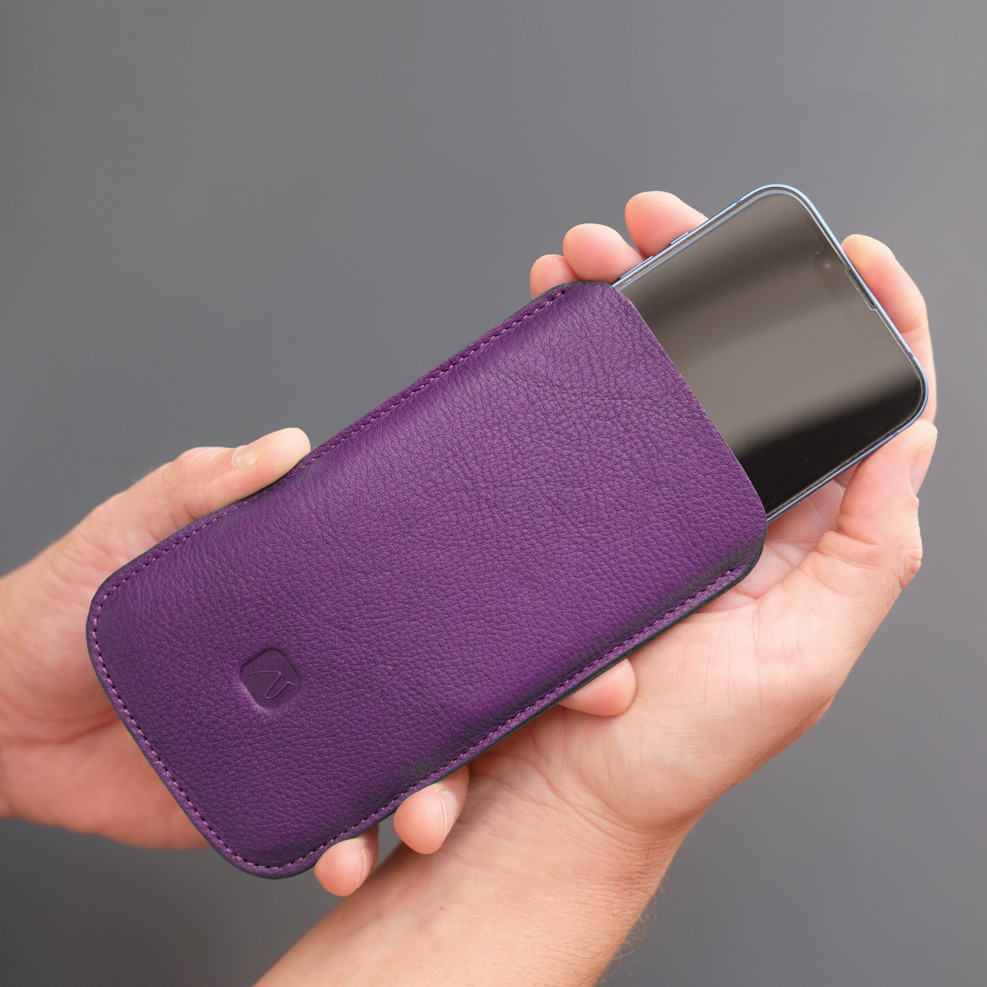 iPhone wird in lila Handyhülle gesteckt
