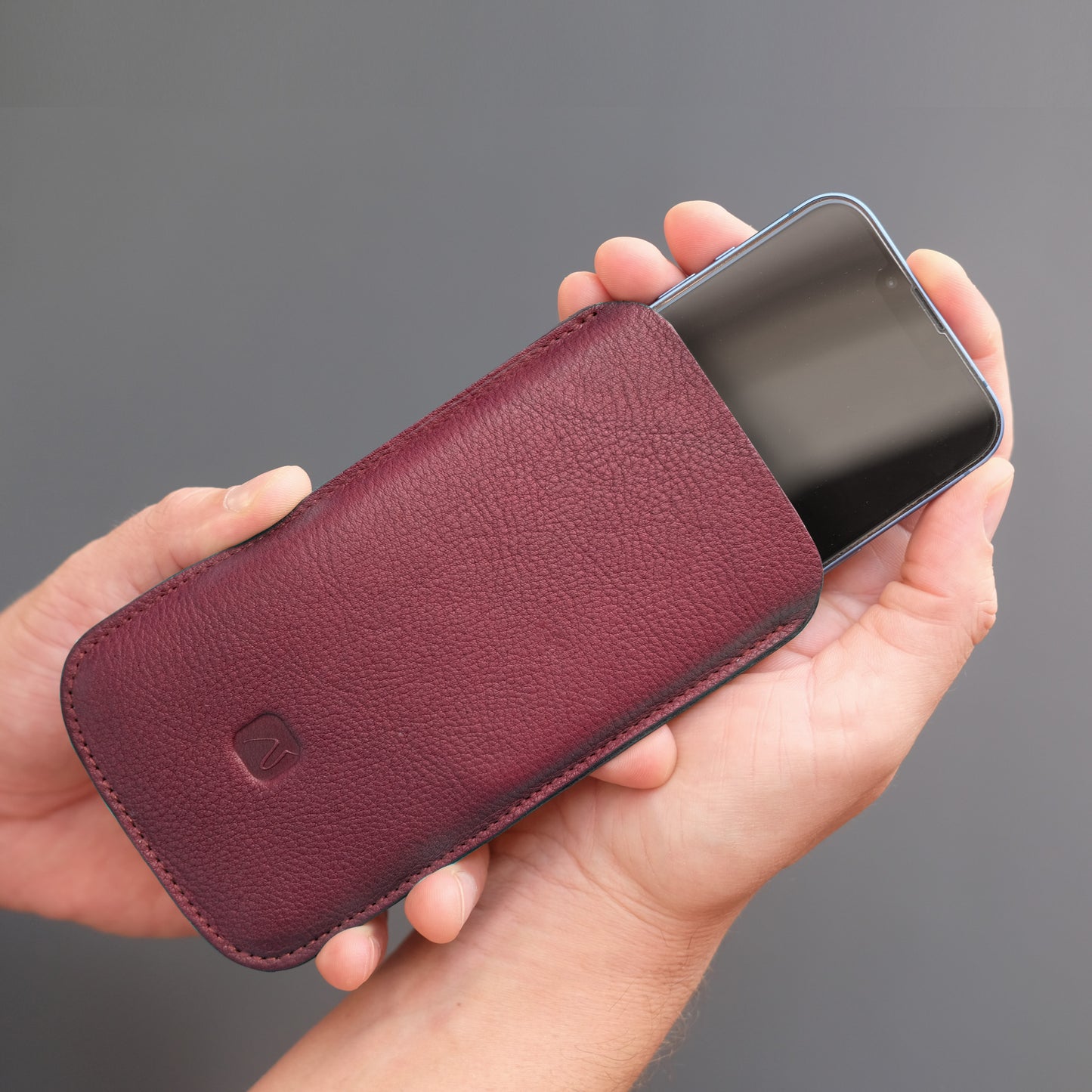 dunkelrotes Handy Sleeve aus Leder mit iPhone
