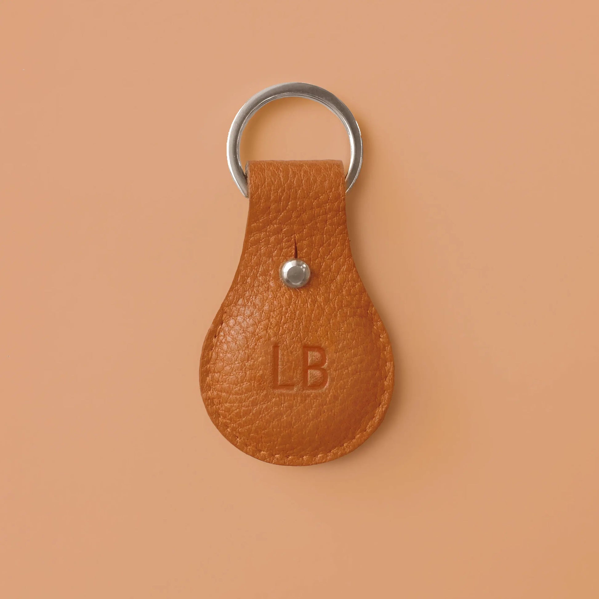 Airtaghülle aus orangefarbenem Leder mit Schlüsselring und eingeprägten Initialen