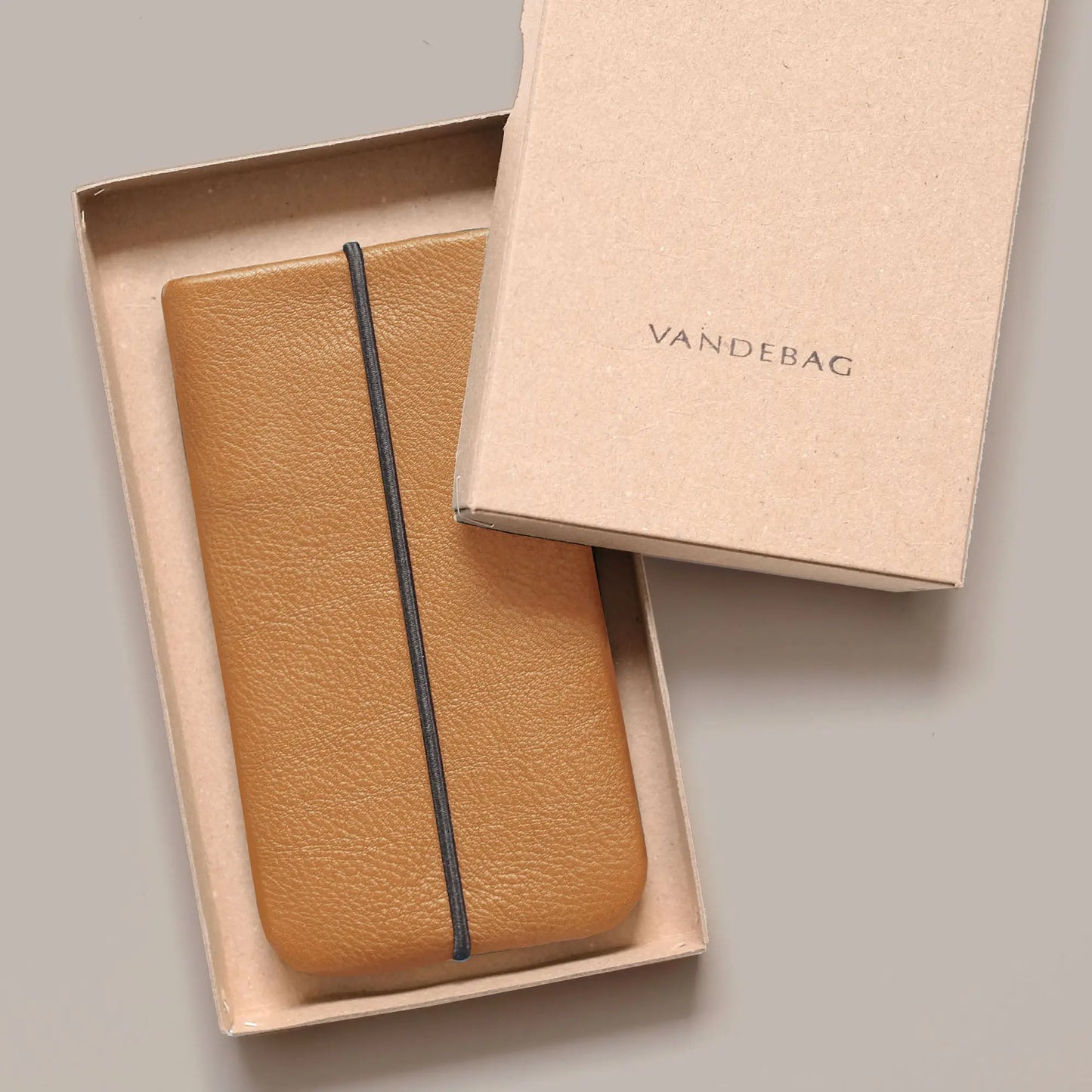 Handyhülle aus Rindsleder in hellbraun liegt in Geschenkbox mit Aufschrift Vandebag