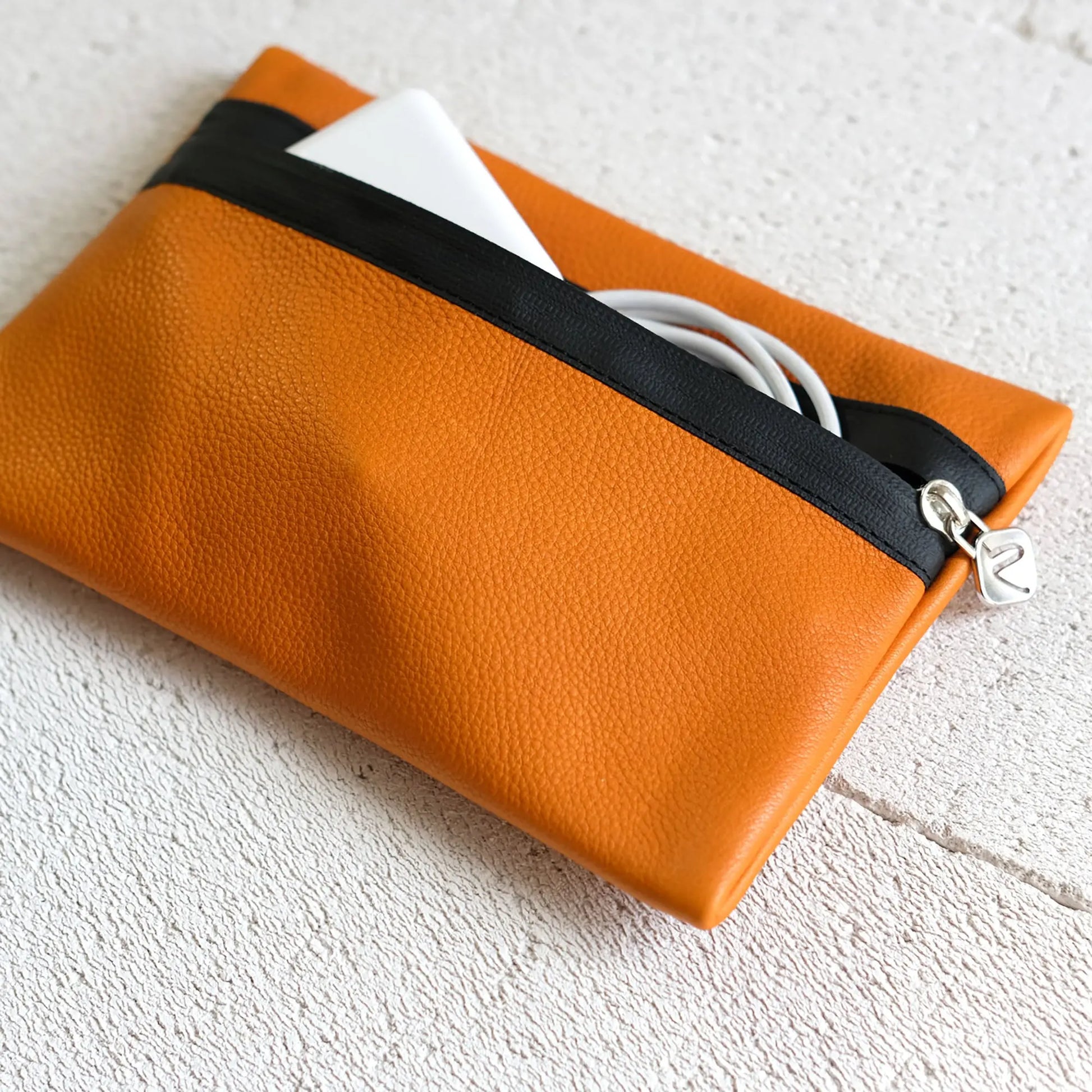 orangefarbene Kabeltasche aus Leder mit Charger und Kabel