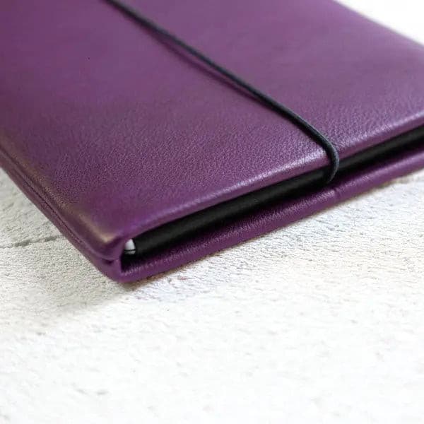 Notebookhülle aus violettem Leder mit Verschlussklappe und Gummiband