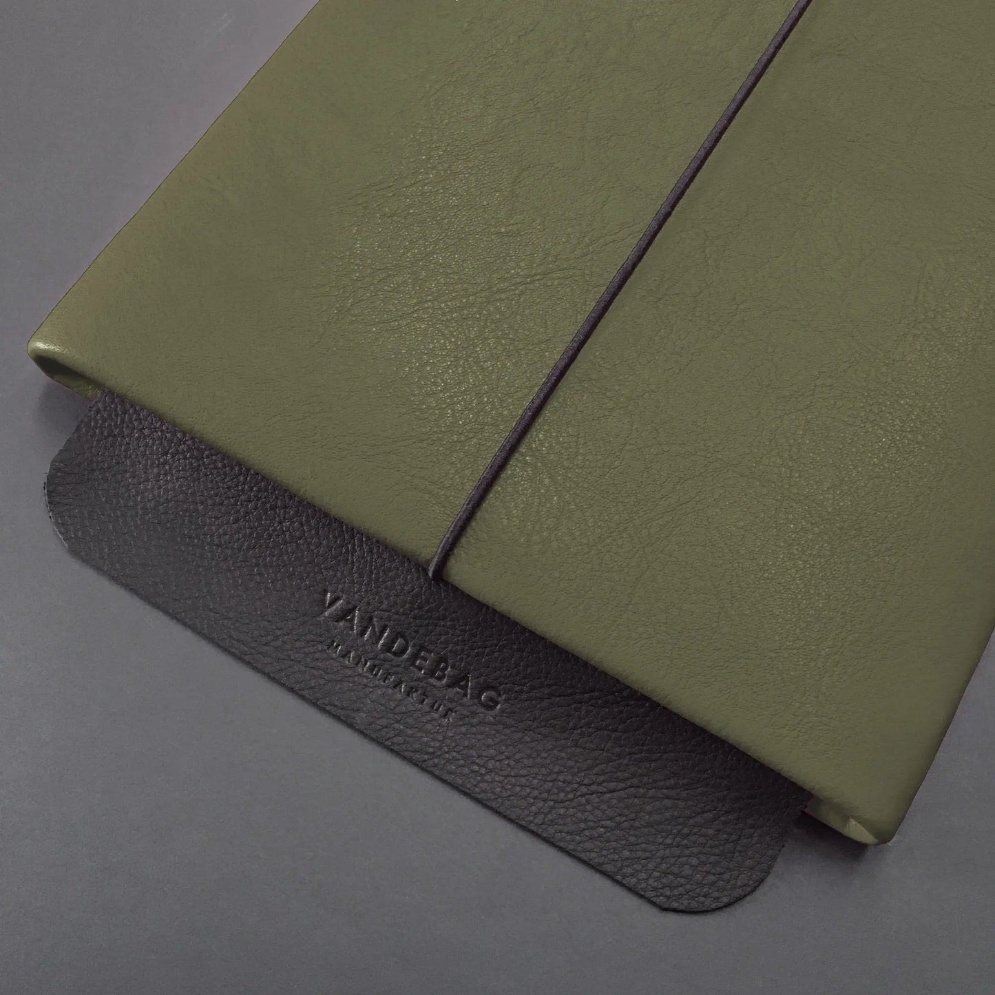 grüne Macbookhülle mit schwarzer Verschlussklappe mit Vandebag Prägung