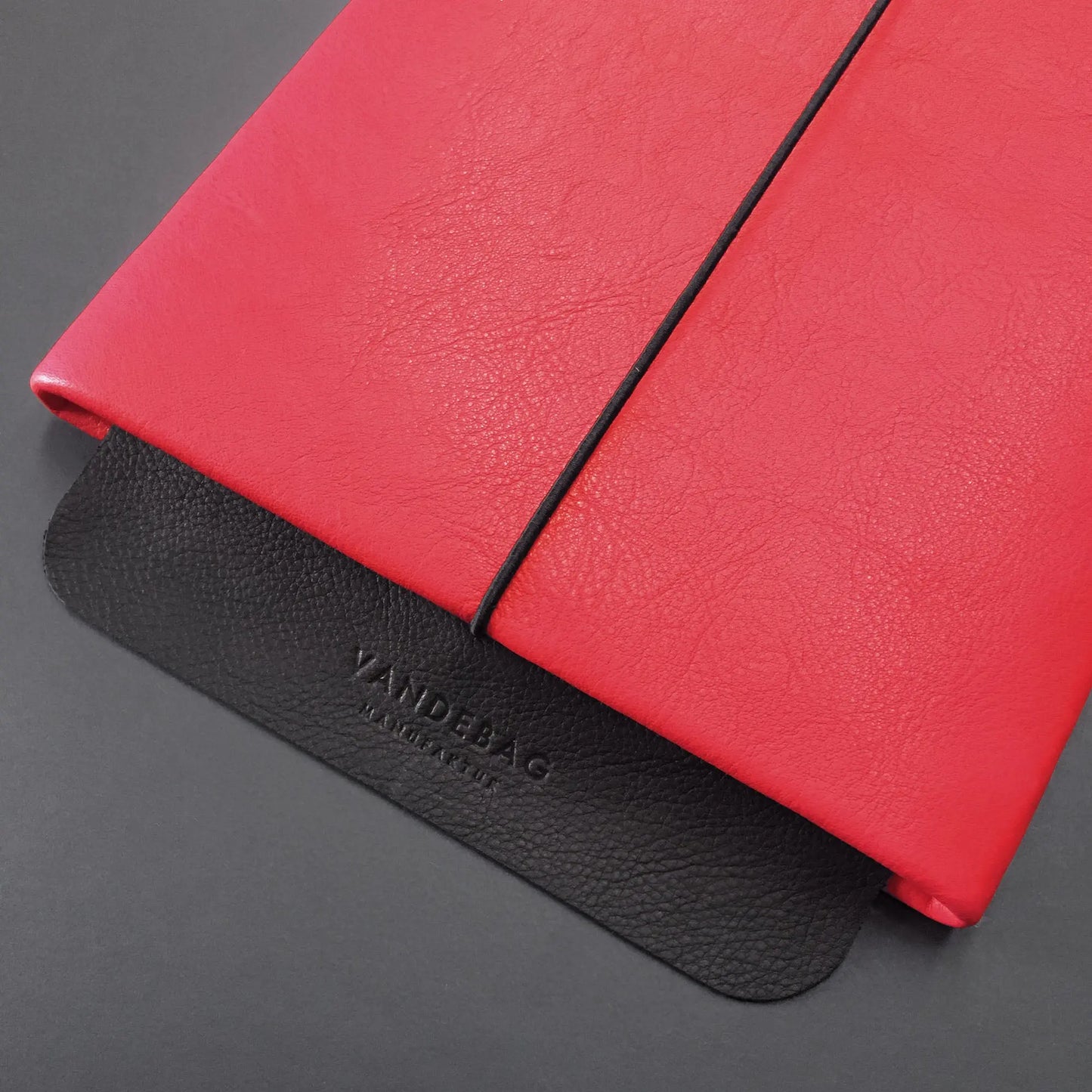 Lederhülle für ein iPad mit scharzer Lederklappe auf der Vandebag Manufaktur eingeprägt ist.